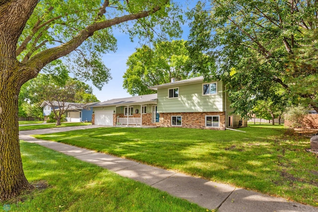 tri-level home with a front lawn, a garage, and covered porch