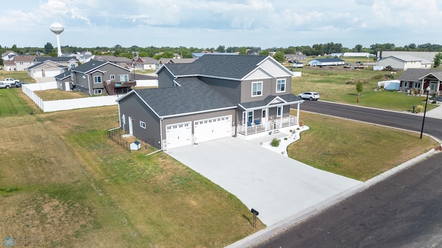 view of front facade with a garage, a front lawn, and covered porch