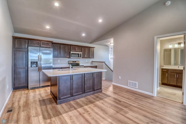 kitchen with a center island with sink, light hardwood / wood-style flooring, stainless steel appliances, and lofted ceiling