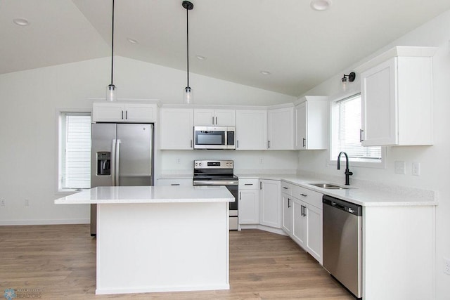 kitchen featuring lofted ceiling, a center island, stainless steel appliances, and light hardwood / wood-style floors