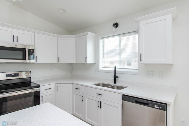 kitchen featuring lofted ceiling, stainless steel appliances, sink, and white cabinets