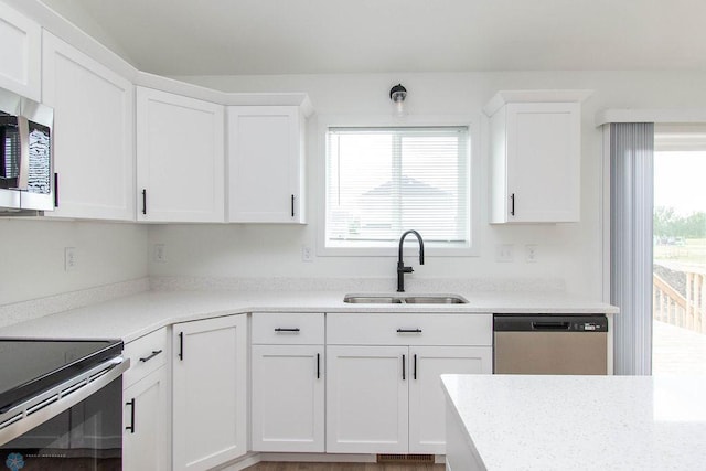 kitchen featuring appliances with stainless steel finishes, white cabinetry, and sink