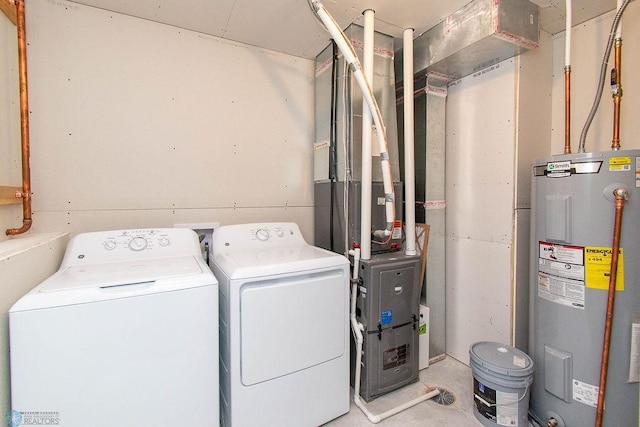 clothes washing area featuring electric water heater and independent washer and dryer