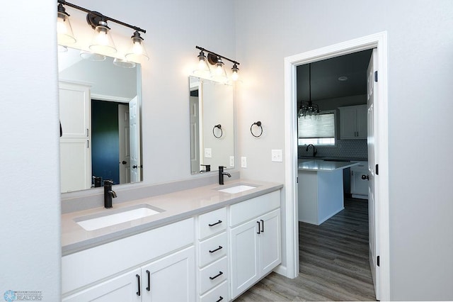 bathroom featuring wood-type flooring, decorative backsplash, and vanity