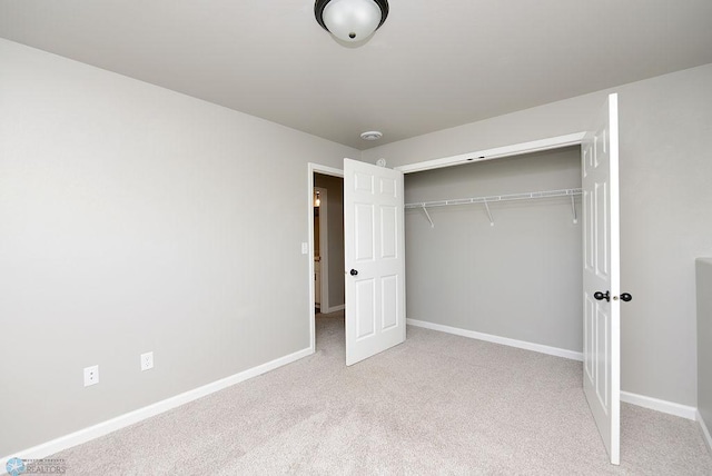 unfurnished bedroom featuring carpet flooring and a closet