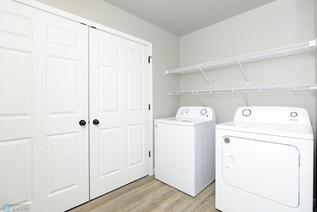 washroom with light wood-type flooring and washer and clothes dryer