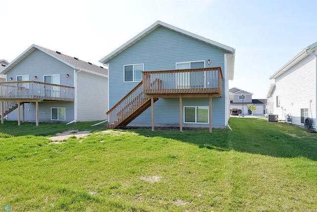 rear view of property with a wooden deck, central AC unit, and a yard