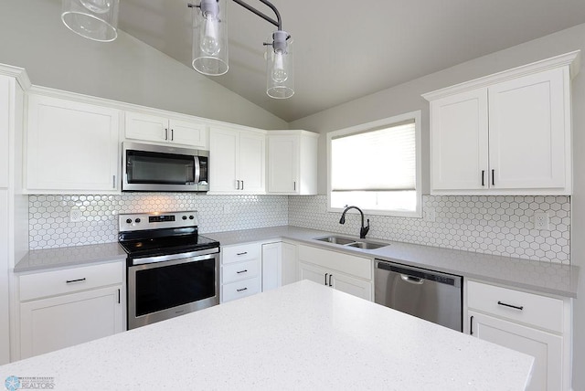 kitchen featuring vaulted ceiling, tasteful backsplash, stainless steel appliances, and sink