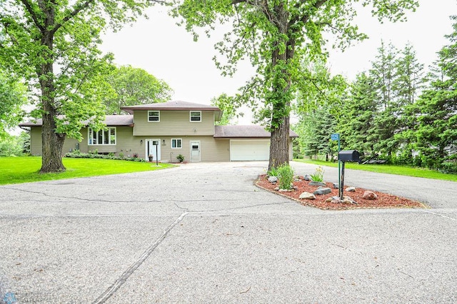 view of front of property with a garage and a front lawn