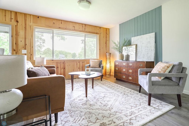 sitting room featuring light hardwood / wood-style flooring and wooden walls