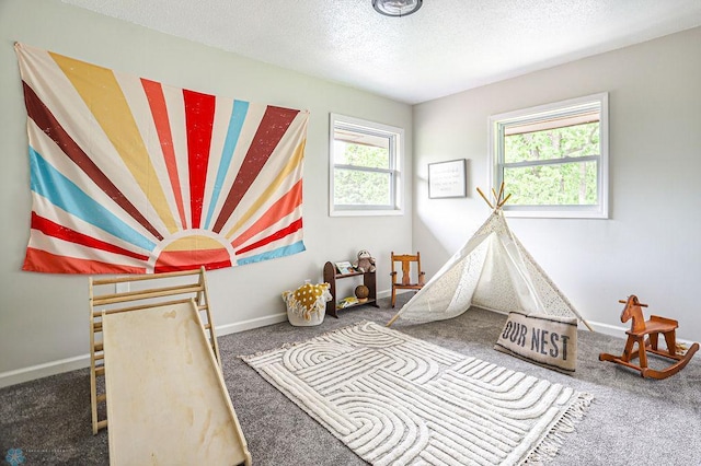 rec room featuring carpet and a textured ceiling