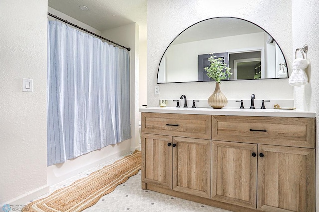 bathroom featuring shower / bath combo with shower curtain and vanity