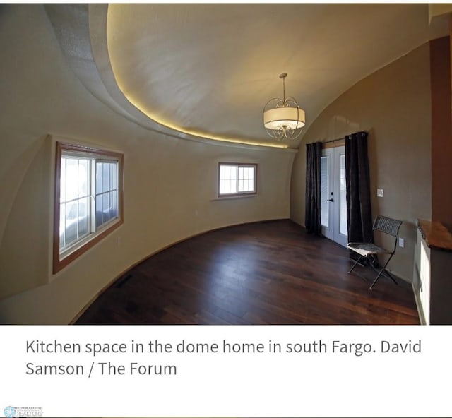 interior space featuring a notable chandelier and dark wood-type flooring