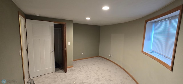 unfurnished bedroom with light carpet and a closet