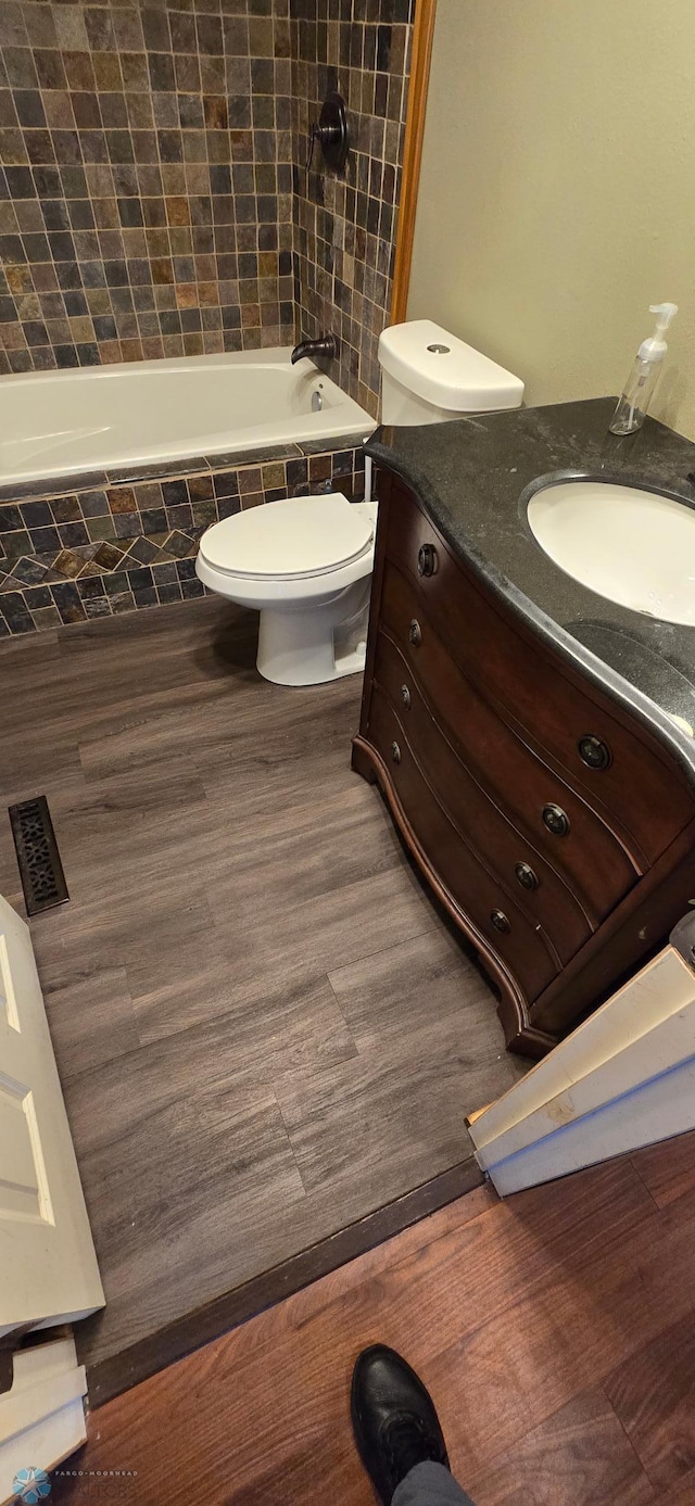 full bathroom with tiled shower / bath combo, vanity, and toilet