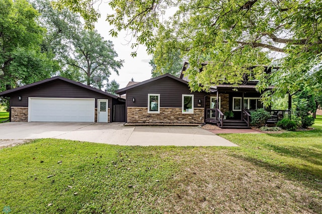 view of front of property featuring covered porch, a front yard, and a garage