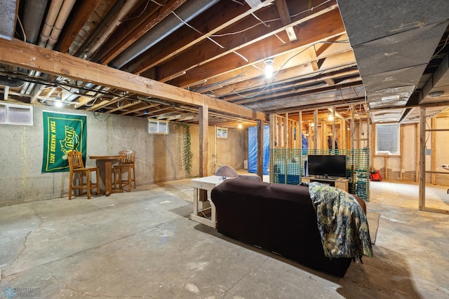 basement featuring bar area and a wall unit AC