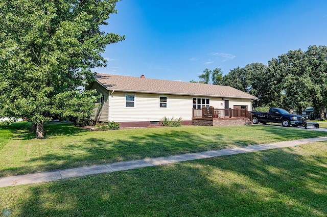 ranch-style home featuring a front yard and a wooden deck