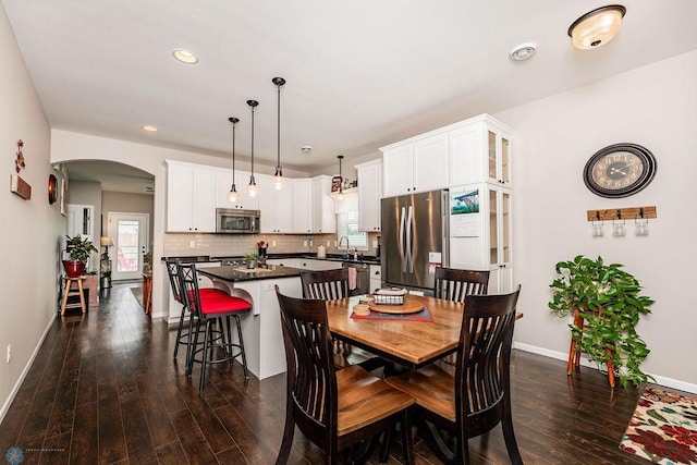 dining room with dark wood-type flooring, plenty of natural light, and sink