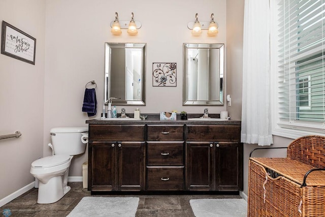 bathroom featuring toilet, plenty of natural light, and vanity