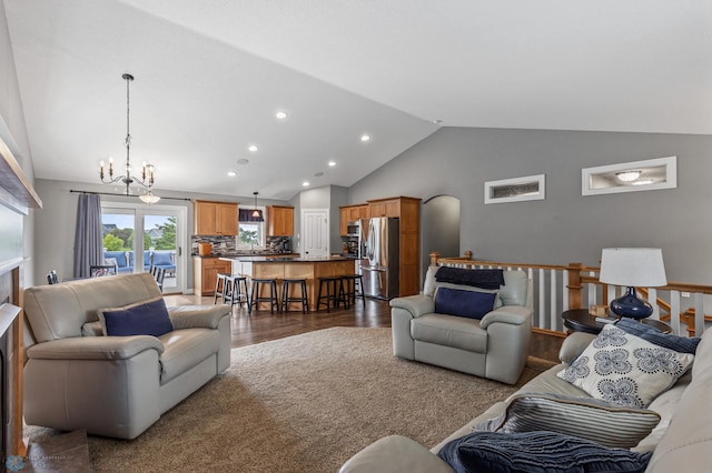 living room with lofted ceiling, dark wood-type flooring, and a chandelier