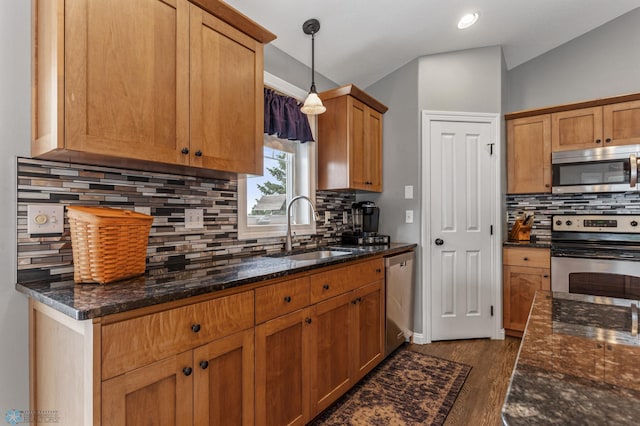 kitchen featuring hanging light fixtures, appliances with stainless steel finishes, dark hardwood / wood-style flooring, sink, and lofted ceiling