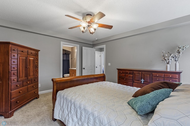 bedroom with ensuite bath, light carpet, ceiling fan, and a textured ceiling