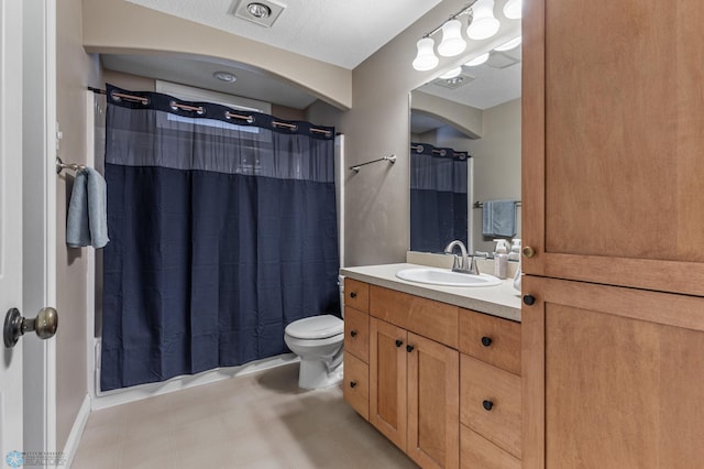 bathroom featuring vanity, toilet, and walk in shower