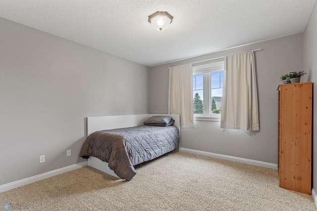 bedroom with light carpet and a textured ceiling