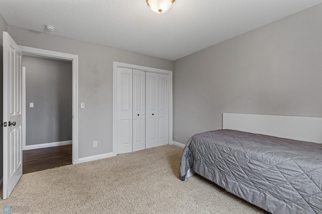 bedroom featuring a closet, a textured ceiling, and carpet floors