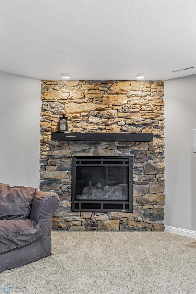 interior details featuring a textured ceiling, carpet flooring, and a fireplace