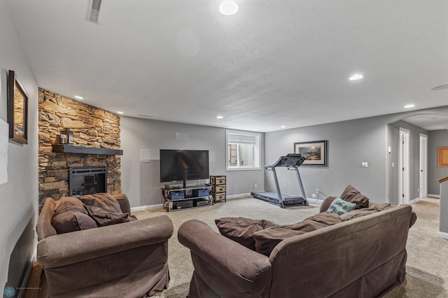 carpeted living room with a textured ceiling and a stone fireplace