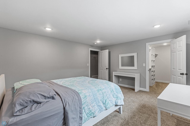 bedroom with carpet flooring and a walk in closet