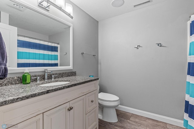 bathroom featuring toilet, hardwood / wood-style flooring, and vanity