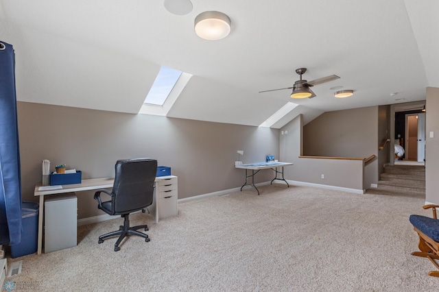 carpeted office space featuring ceiling fan and lofted ceiling with skylight