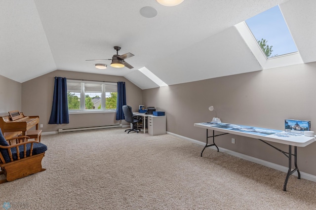 carpeted office with a baseboard heating unit, vaulted ceiling with skylight, and ceiling fan