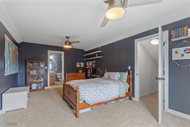 bedroom featuring ceiling fan, connected bathroom, light carpet, and vaulted ceiling