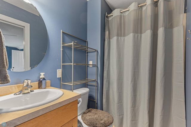 bathroom featuring vanity, toilet, and curtained shower