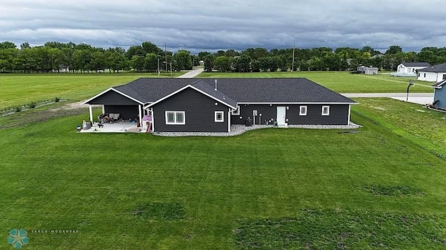 back of house with a yard and a patio