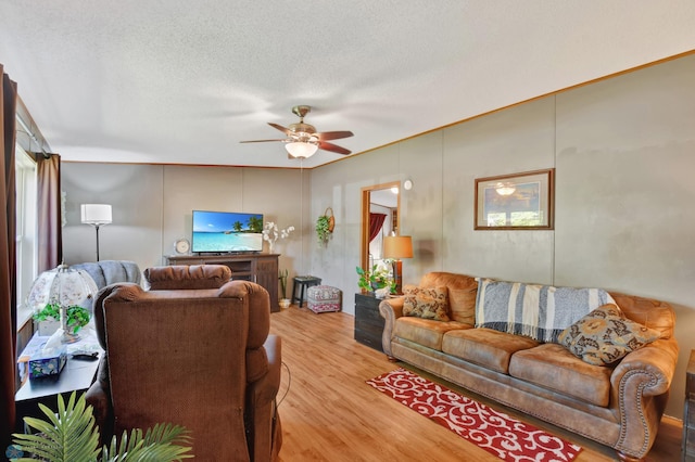 living room with light wood-type flooring, a textured ceiling, and ceiling fan