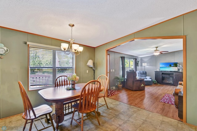 dining room with lofted ceiling, ceiling fan with notable chandelier, wood-type flooring, and a textured ceiling