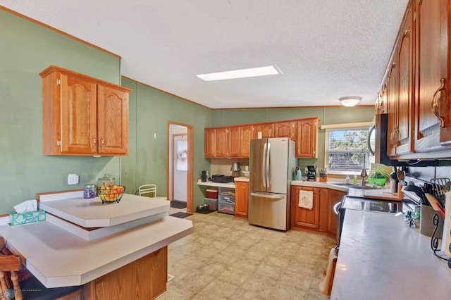 kitchen with lofted ceiling, stainless steel appliances, and a textured ceiling