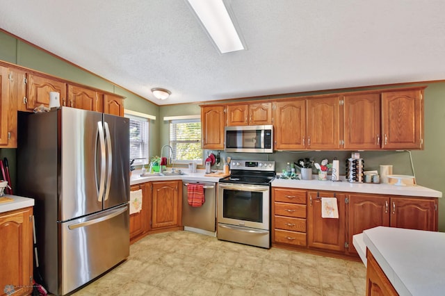 kitchen with a textured ceiling, sink, and appliances with stainless steel finishes