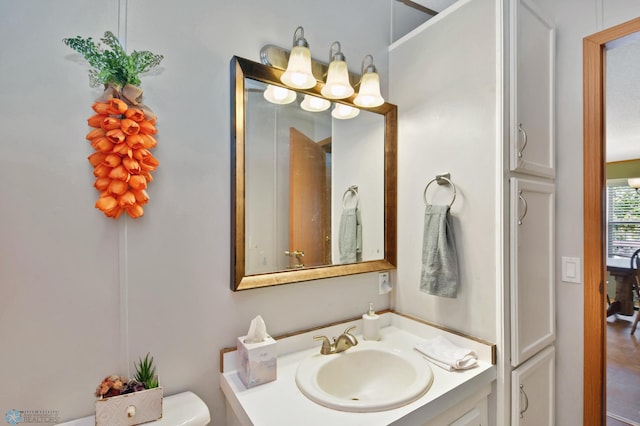 bathroom with vanity, toilet, and wood-type flooring