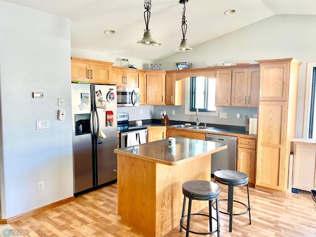 kitchen featuring light hardwood / wood-style flooring, a center island, sink, appliances with stainless steel finishes, and lofted ceiling