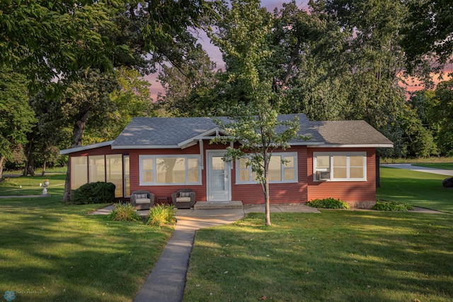 view of front of property featuring cooling unit and a lawn