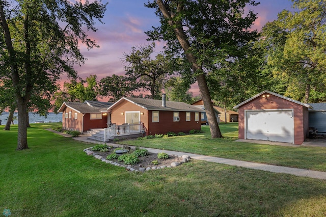 single story home featuring an outdoor structure, a garage, and a lawn