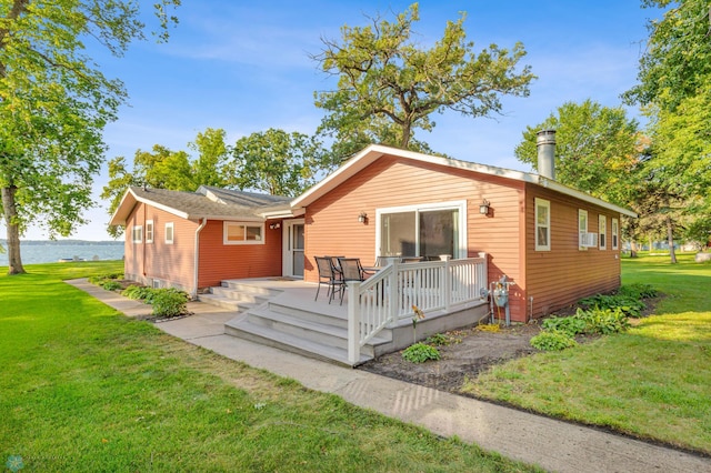 rear view of property featuring a yard and a wooden deck