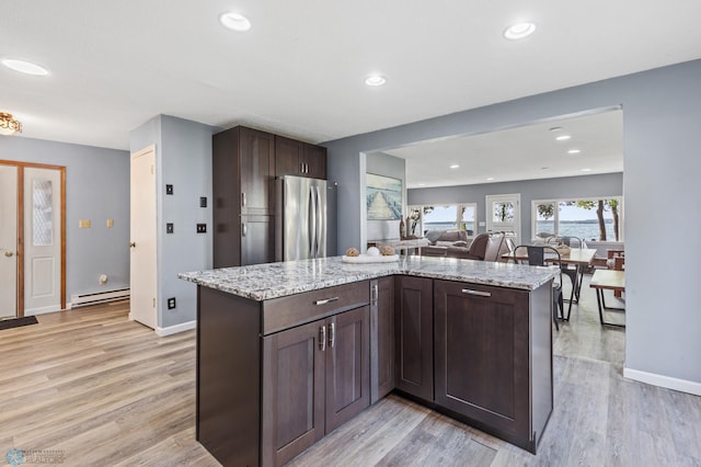 kitchen with a baseboard heating unit, light wood-type flooring, and stainless steel refrigerator