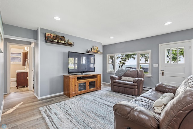 living room with baseboard heating and hardwood / wood-style floors